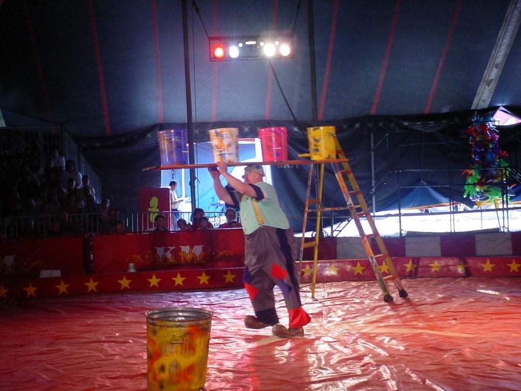 Circus performer climbing ladder under tent lights