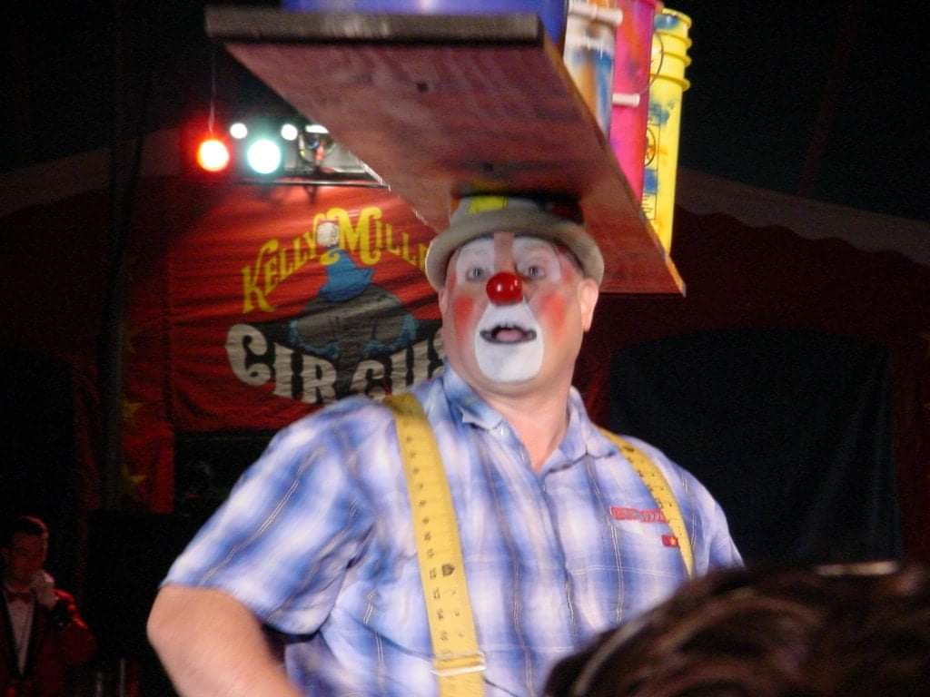 Clown performer at circus tent at night