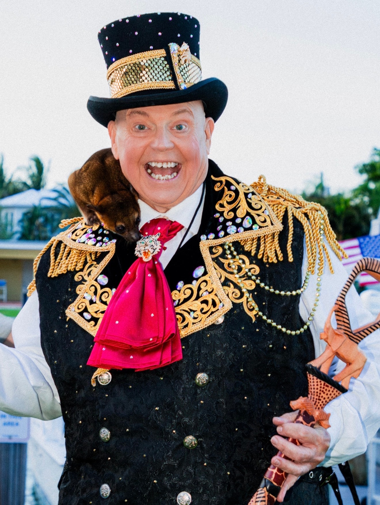 Ringmaster in ornate jacket holding monkey puppet
